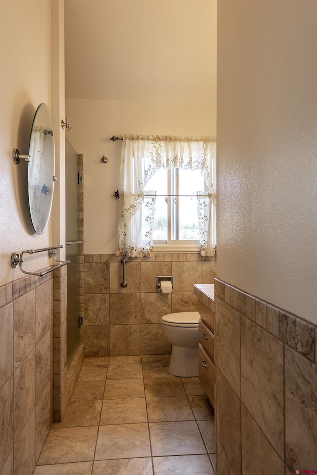 16303 6760th Rd, Montrose, CO 81401 - full bath featuring tile walls, a stall shower, toilet, tile patterned floors, and a wainscoted wall