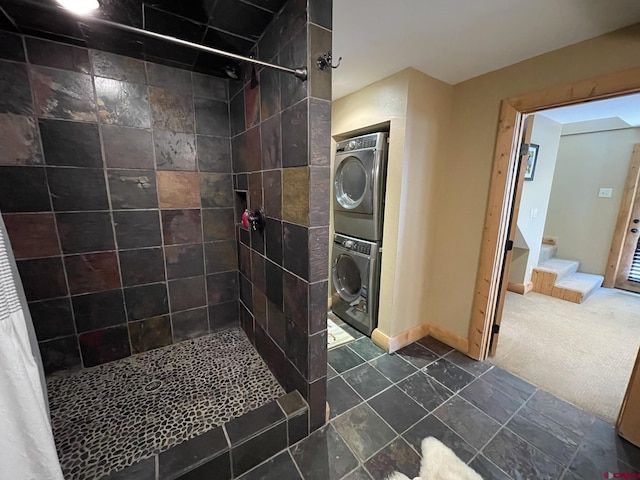 209 Deer Path Ln, Almont, CO 81230 - bathroom with stacked washing machine and dryer, tiled shower, and baseboards