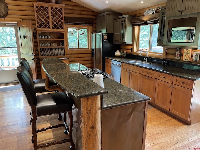 209 Deer Path Ln, Almont, CO 81230 - kitchen featuring a sink, rustic walls, light wood-style floors, lofted ceiling, and glass insert cabinets