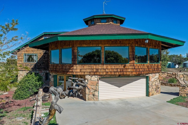 14120 Rd 26, Dolores, CO 81323 - view of front of house with stone siding, driveway, and a garage