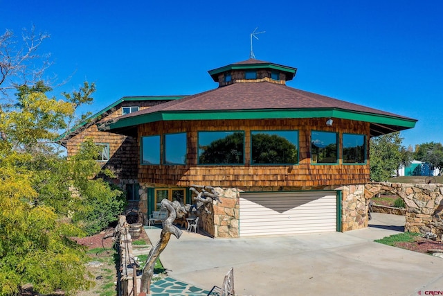 14120 Rd 26, Dolores, CO 81323 - view of front of house with an attached garage, driveway, stone siding, and roof with shingles