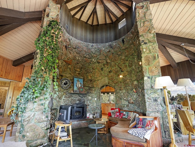 14120 Rd 26, Dolores, CO 81323 - living room featuring a wood stove, beam ceiling, high vaulted ceiling, wooden walls, and stone finish flooring