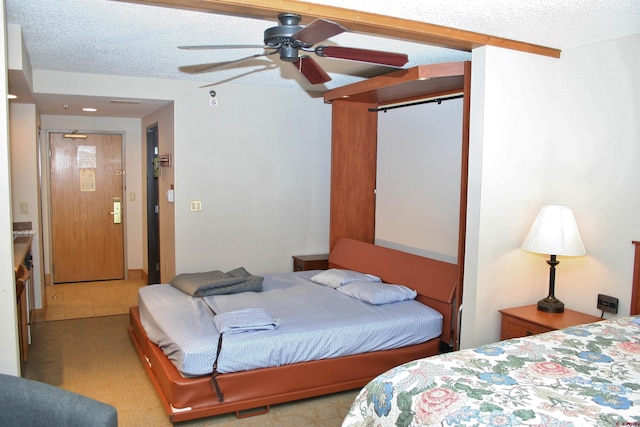 bedroom with a textured ceiling, a ceiling fan, and carpet floors