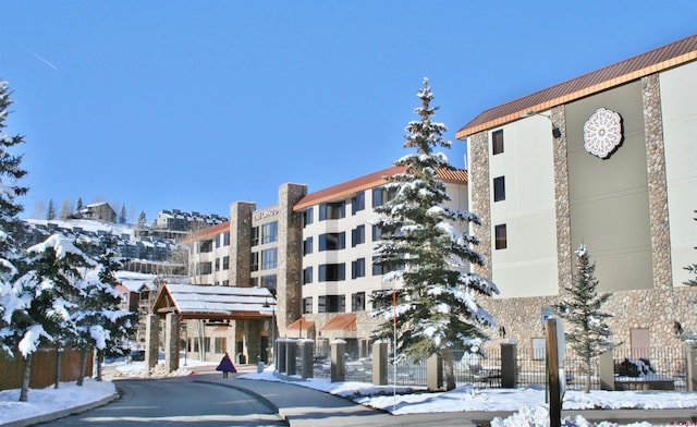 snow covered property featuring a view of apartment building / complex
