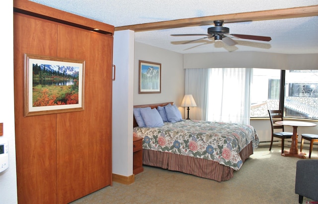 carpeted bedroom with a textured ceiling, baseboard heating, and a ceiling fan