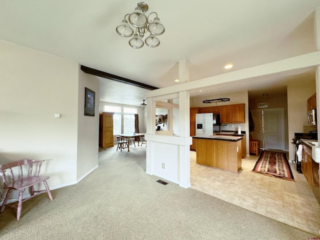 360 Forest Hill Rd, Ridgway, CO 81432 - kitchen with white fridge with ice dispenser, light colored carpet, a chandelier, brown cabinetry, and open floor plan