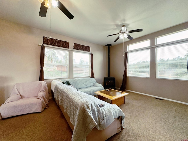 360 Forest Hill Rd, Ridgway, CO 81432 - living area featuring a ceiling fan, a wood stove, carpet flooring, and baseboards