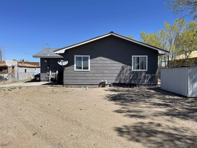 1510 W Sixth St, Alamosa, CO 81101 - rear view of house featuring fence, an outdoor structure, and a storage shed
