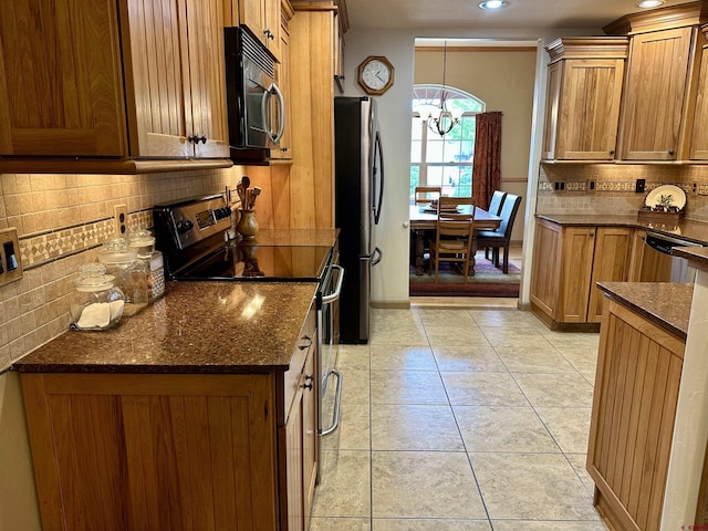 kitchen featuring appliances with stainless steel finishes, tasteful backsplash, a chandelier, brown cabinets, and recessed lighting