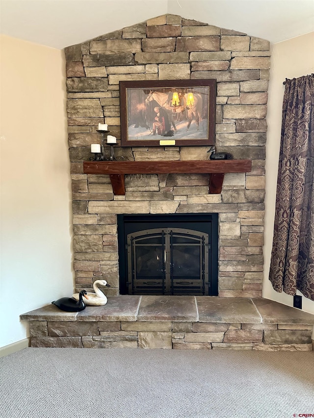 detailed view of a stone fireplace and carpet floors