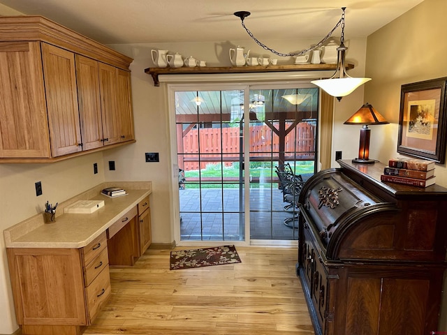 laundry area with light wood-style flooring, baseboards, and an office area