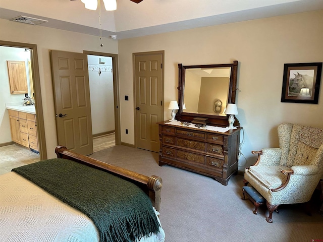 bedroom with ensuite bathroom, baseboards, and light colored carpet