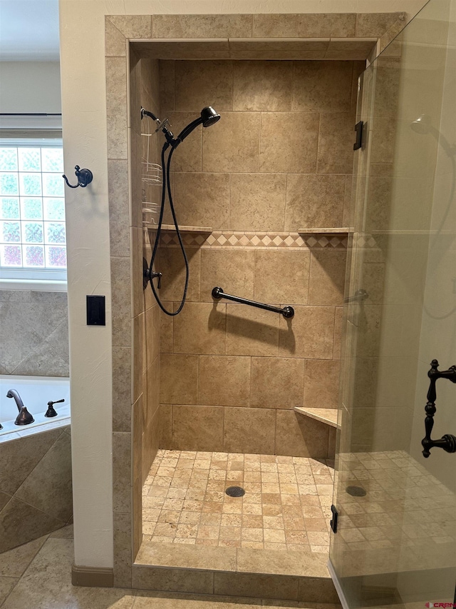 bathroom with a stall shower and a bath