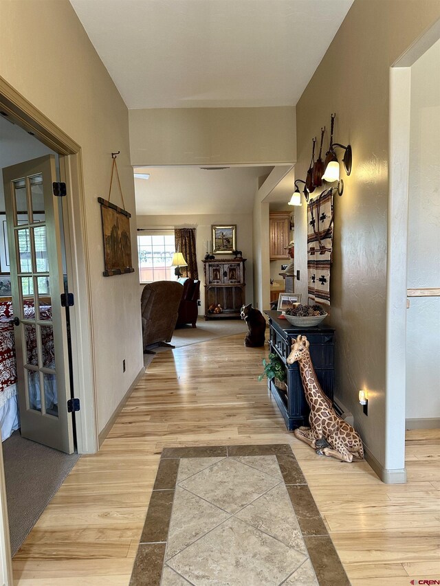 hall featuring light wood-style floors and baseboards