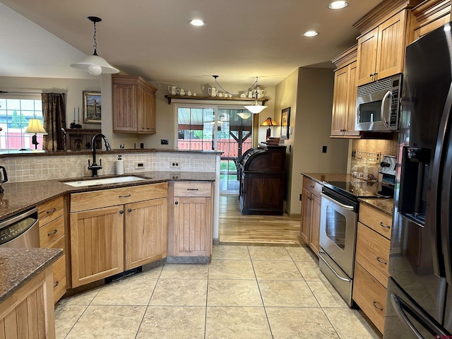 kitchen with appliances with stainless steel finishes, a sink, decorative backsplash, recessed lighting, and plenty of natural light