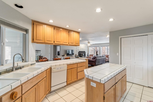 kitchen with white dishwasher, a sink, tile counters, light tile patterned flooring, and recessed lighting