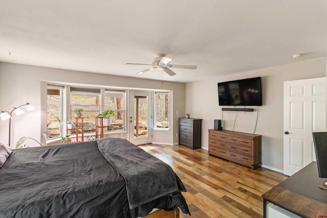 bedroom with access to exterior, wood finished floors, baseboards, and ceiling fan