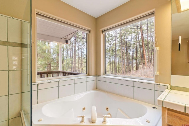 full bathroom featuring healthy amount of natural light and a tub with jets