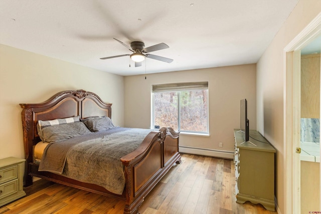 bedroom with baseboard heating, light wood-style flooring, and a ceiling fan