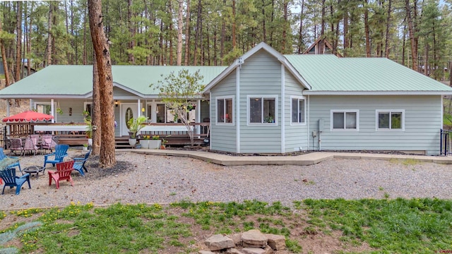 rear view of house with an outdoor fire pit and metal roof