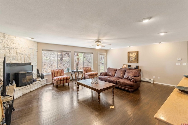 living room with baseboard heating, ceiling fan, dark wood-style floors, baseboards, and a textured ceiling