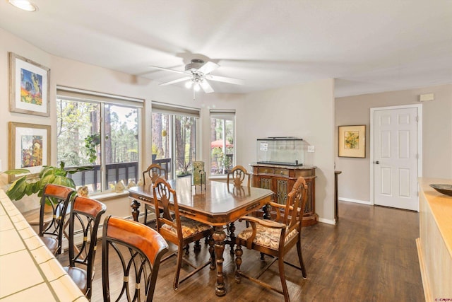 dining room featuring a ceiling fan, baseboards, dark wood-type flooring, and a baseboard radiator