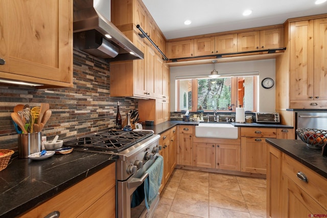 99 River Rd, Durango, CO 81301 - kitchen with high end stove, wall chimney exhaust hood, a sink, dark countertops, and decorative backsplash