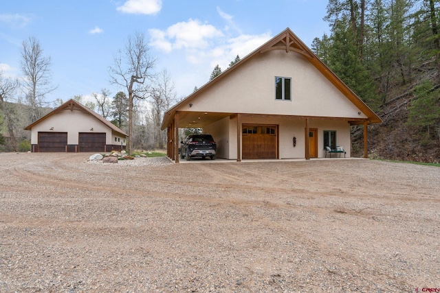 99 River Rd, Durango, CO 81301 - view of front of property featuring a garage, driveway, stucco siding, and an outbuilding