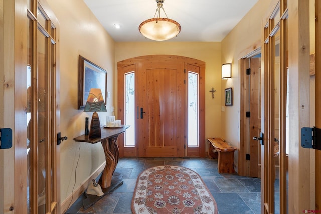 99 River Rd, Durango, CO 81301 - foyer featuring stone tile flooring, healthy amount of natural light, arched walkways, and baseboards