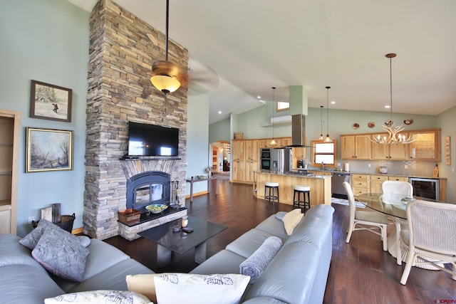 53315 Bull Basin Rd, Mesa, CO 81643 - living room featuring wine cooler, a chandelier, dark wood finished floors, high vaulted ceiling, and a fireplace