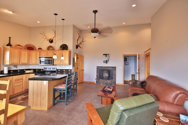 53315 Bull Basin Rd, Mesa, CO 81643 - living room with a high ceiling, a ceiling fan, recessed lighting, baseboards, and a stone fireplace