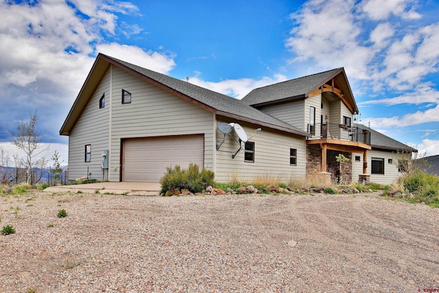 53315 Bull Basin Rd, Mesa, CO 81643 - view of front of property with dirt driveway, a garage, a balcony, and a shingled roof