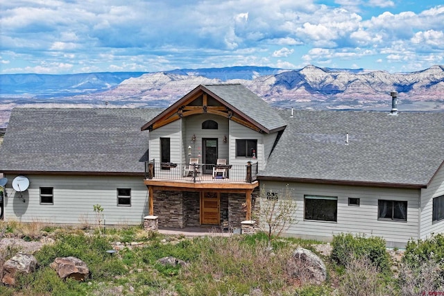53315 Bull Basin Rd, Mesa, CO 81643 - view of front of home with a mountain view, a shingled roof, a balcony, and stone siding