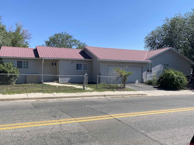 240 S Madison St, Cortez, CO 81321 - ranch-style house with an attached garage, a fenced front yard, metal roof, and driveway