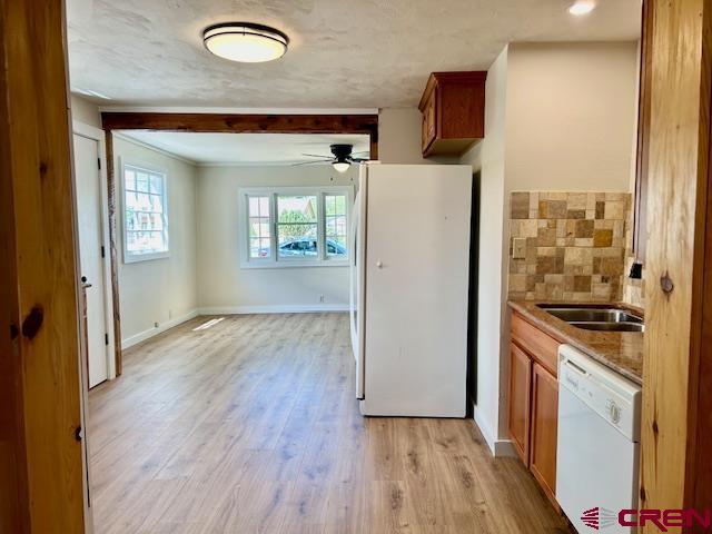 1414 Bluff St, Delta, CO 81416 - kitchen featuring white appliances, brown cabinets, a ceiling fan, a sink, and light wood finished floors
