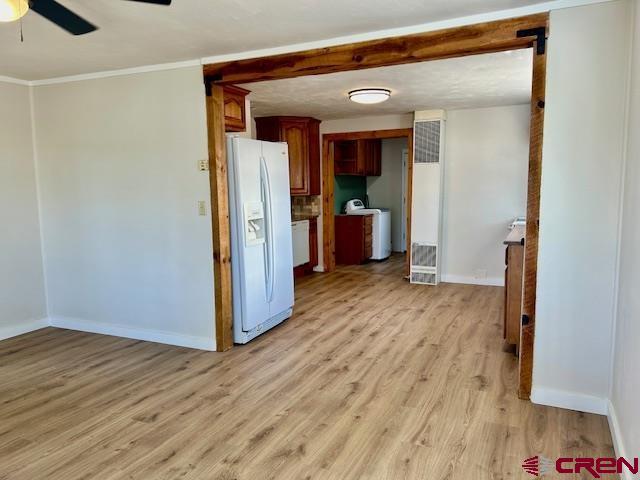 1414 Bluff St, Delta, CO 81416 - spare room featuring ceiling fan, light wood-style flooring, baseboards, ornamental molding, and washer / clothes dryer