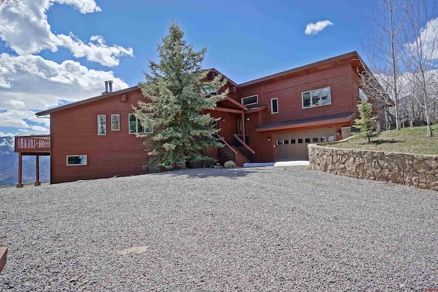 view of front of property featuring a garage, driveway, and stairs