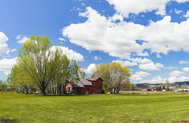 view of green lawn featuring a mountain view