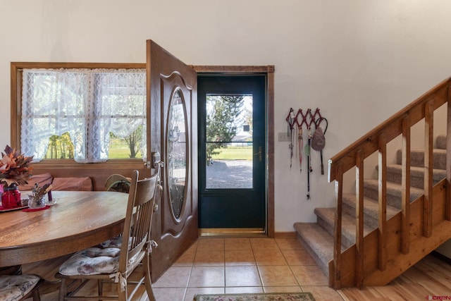 entrance foyer featuring stairway and light tile patterned floors