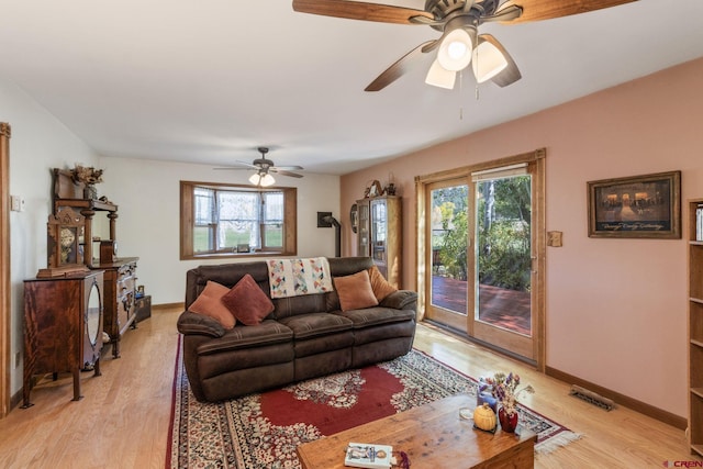 living area featuring light wood-style flooring, healthy amount of natural light, and baseboards