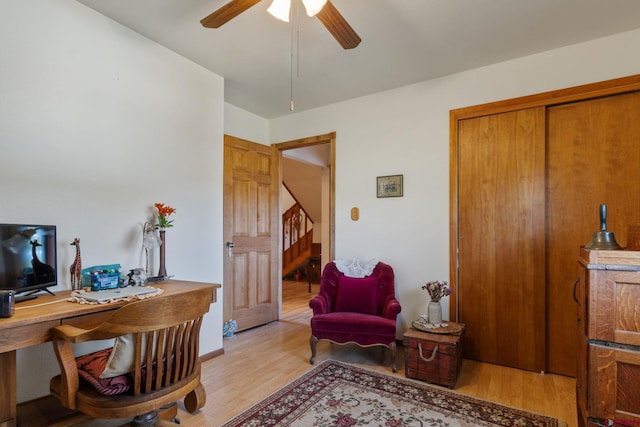 living area featuring light wood-style flooring, ceiling fan, and a desk