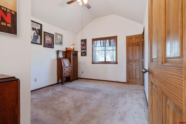 unfurnished bedroom featuring carpet floors, lofted ceiling, ceiling fan, and baseboards