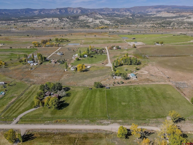 aerial view of property and surrounding area featuring rural landscape and a mountainous background