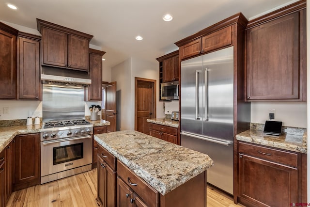32 Cinnamon Mountain Rd, Mount Crested Butte, CO 81225 - kitchen with appliances with stainless steel finishes, under cabinet range hood, light wood-type flooring, recessed lighting, and a kitchen island