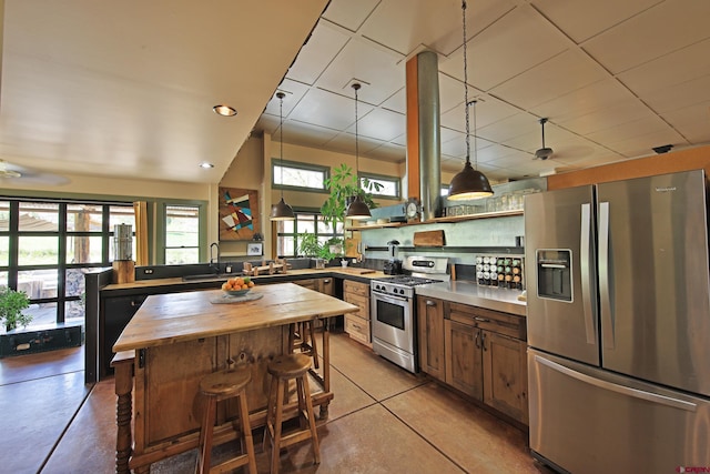10491 54 7/10 Rd, Molina, CO 81646 - kitchen with stainless steel appliances, butcher block countertops, open shelves, a kitchen breakfast bar, and concrete floors