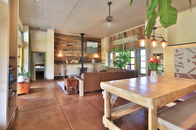 10491 54 7/10 Rd, Molina, CO 81646 - dining space with a wood stove, wooden walls, and concrete flooring