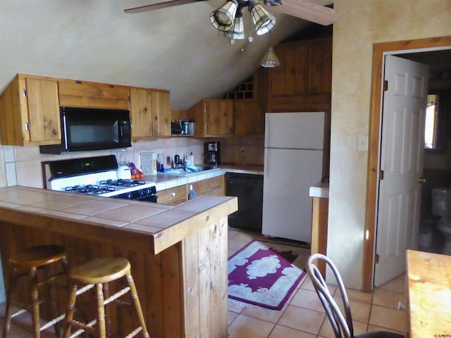 858 Reese St, Silverton, CO 81433 - kitchen featuring black appliances, tile counters, a ceiling fan, light tile patterned floors, and vaulted ceiling