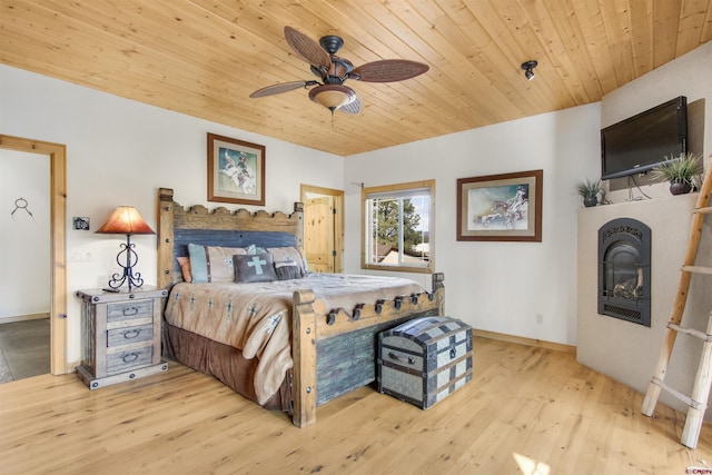 584 Oren Rd, Pagosa Springs, CO 81147 - bedroom with wood finished floors, a glass covered fireplace, baseboards, wooden ceiling, and a ceiling fan