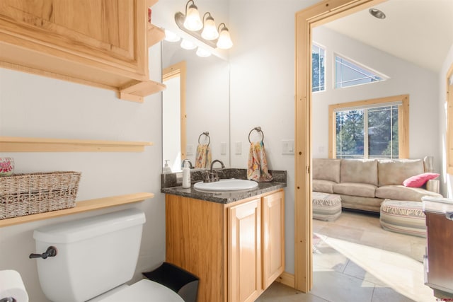 584 Oren Rd, Pagosa Springs, CO 81147 - bathroom featuring toilet, vanity, tile patterned flooring, and vaulted ceiling