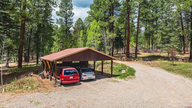 520 Los Ranchitos Dr, Durango, CO 81301 - view of parking featuring a carport, gravel driveway, and a forest view
